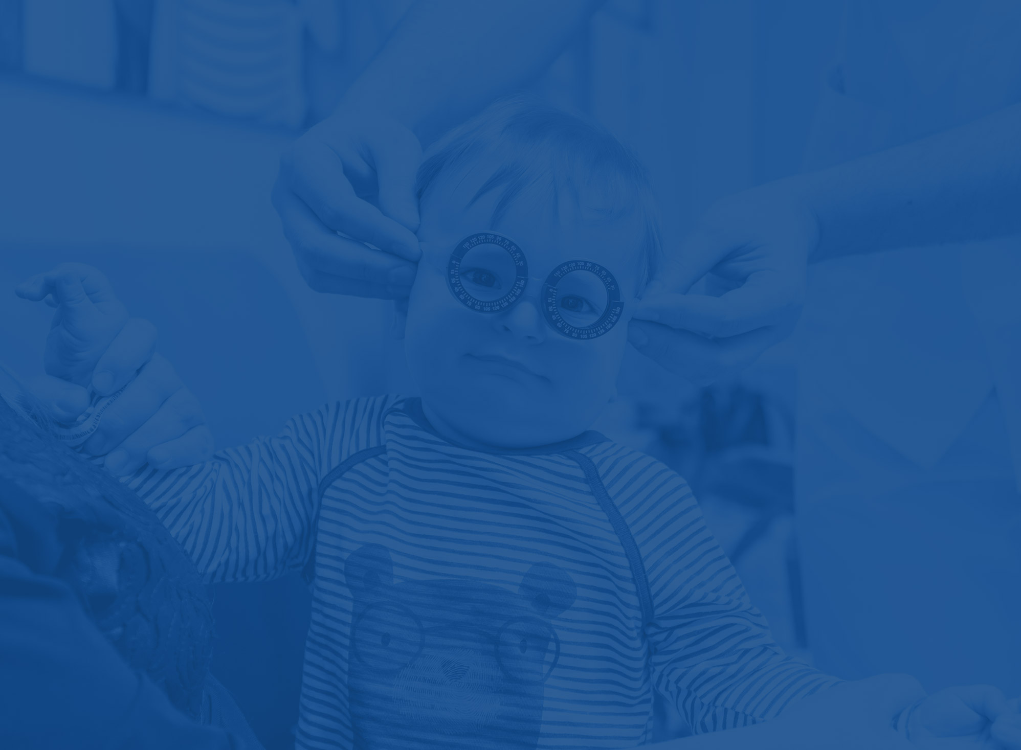 Imagen de un bebé riendo y sonriendo con gafas de corrección de la visión.